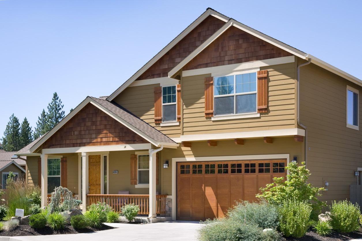 House plan exterior featuring a covered front porch, two stories, wood shingle gables, and a multi-pane garage door.
