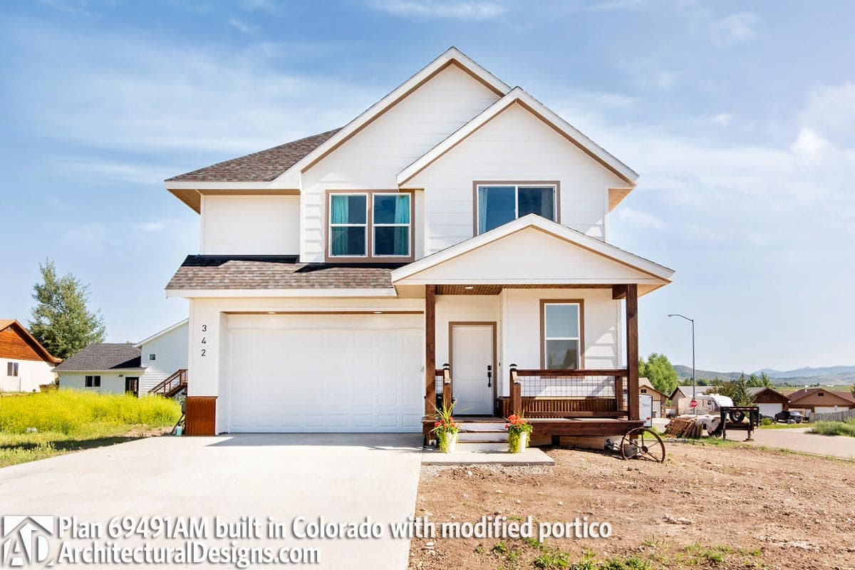 Two-story house plan exterior with a prominent gable roof, front-facing garage, and a covered front porch with a railing.