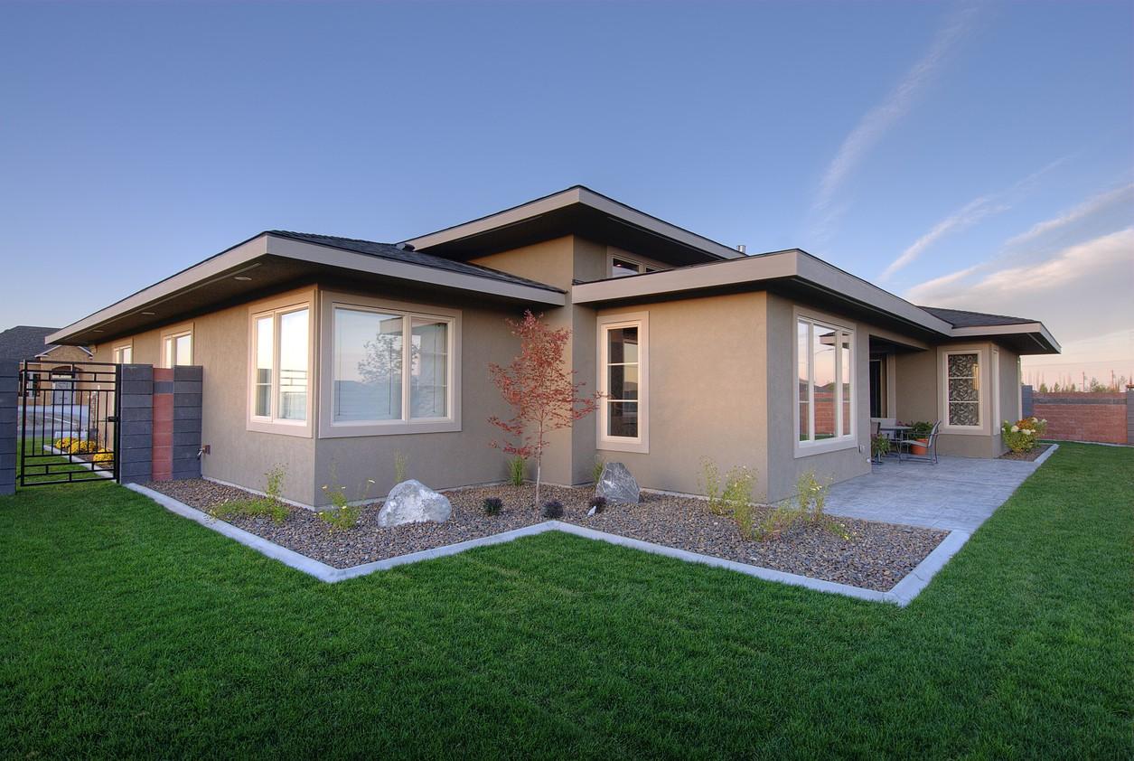 Ranch style house plan exterior with multiple gables, large windows, and a patio.