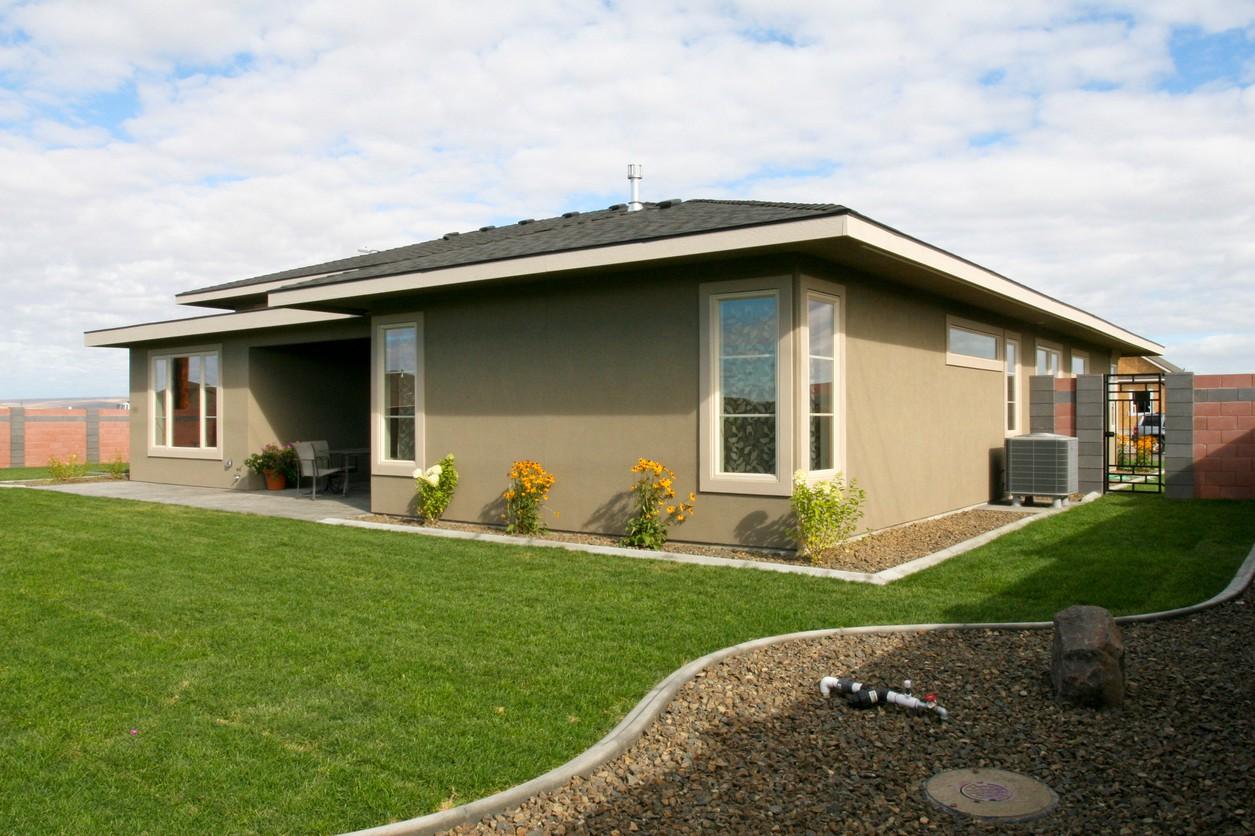 House plan exterior: one-story modern home with covered patio, large bay window, and dark asphalt shingle roof.