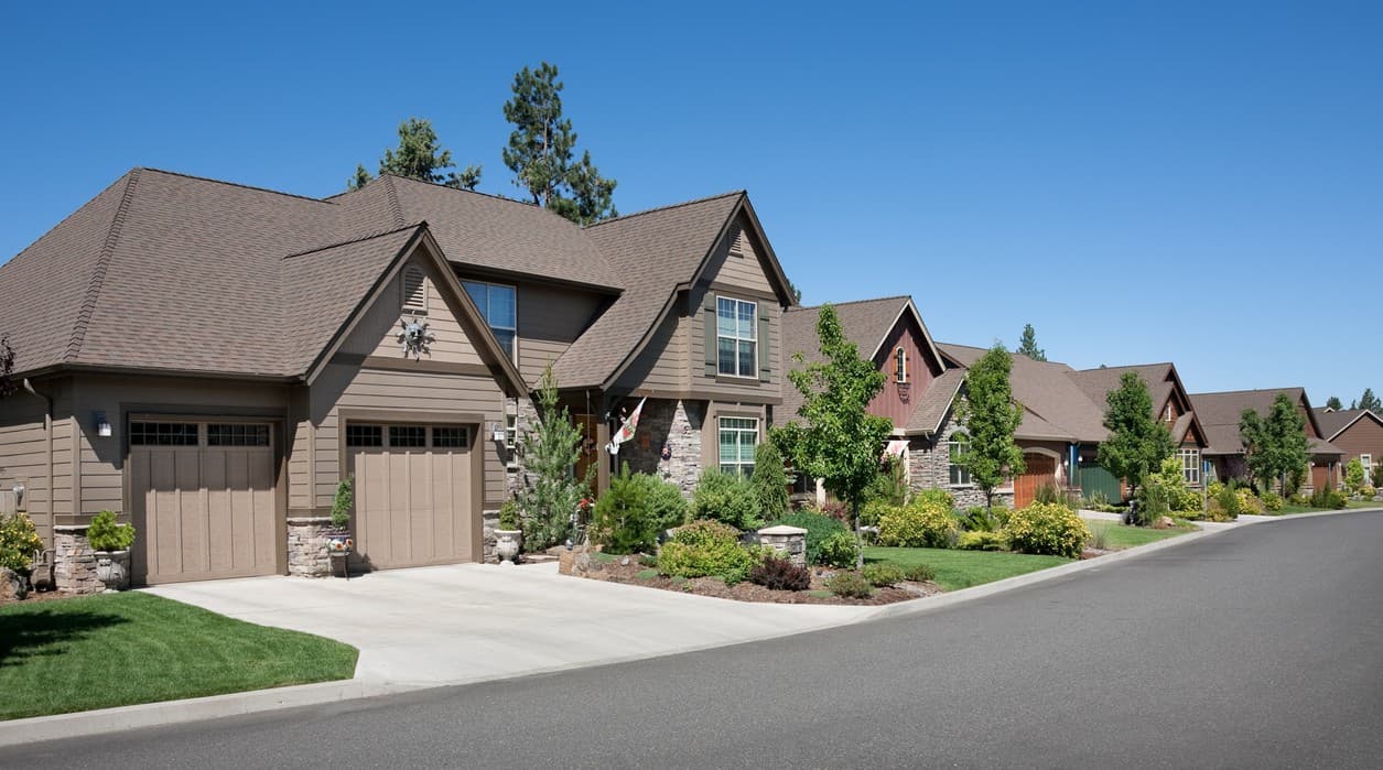 House plan exterior featuring a two-story home with gabled roofs, stone accents, and a side-entry garage.