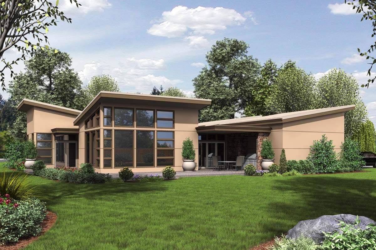 Modern house plan exterior with a low-pitched roof, expansive glass windows, and a covered patio with outdoor kitchen.