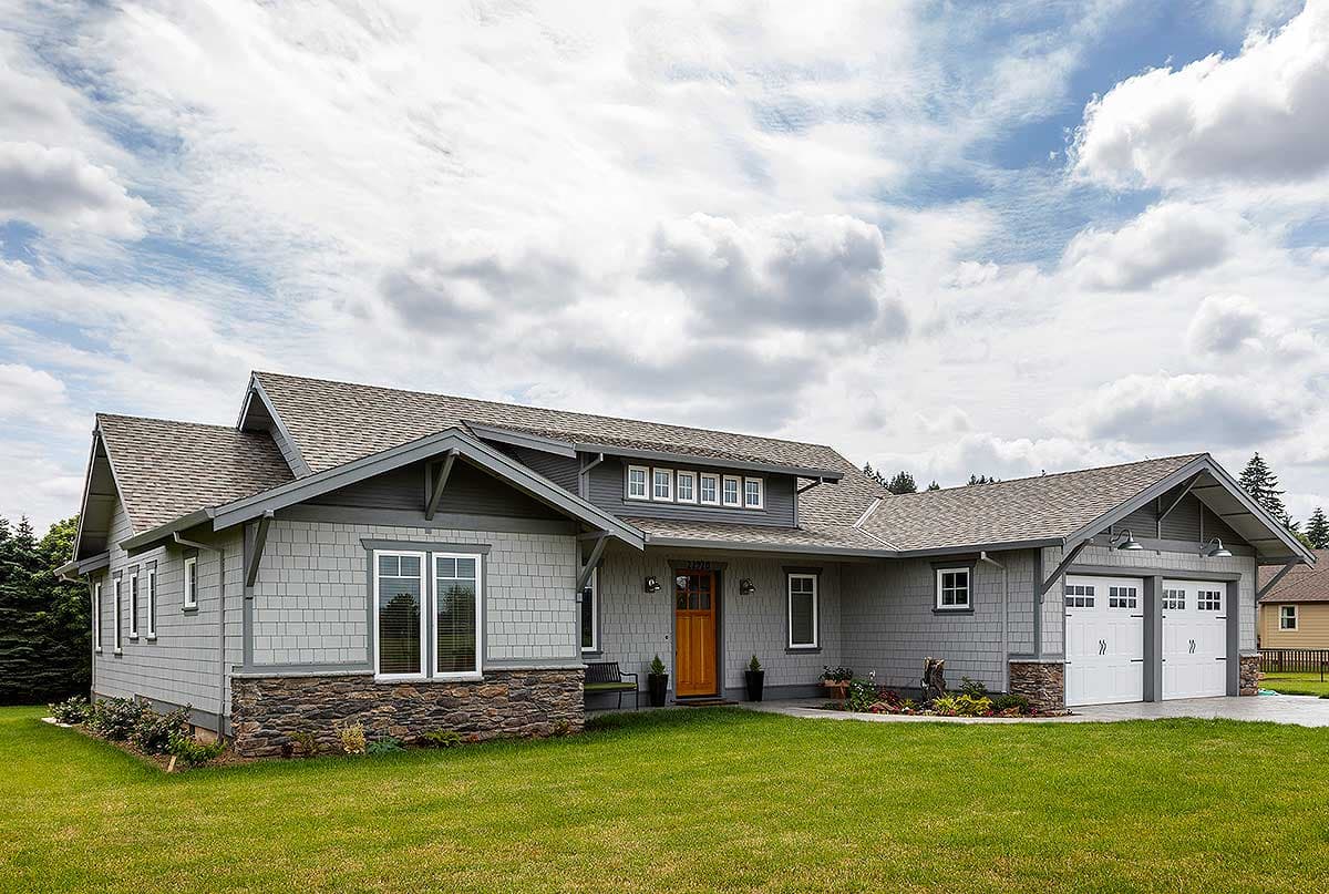 Craftsman house plan exterior with gray shake siding, stone foundation, gables, dormers, and a dual garage.