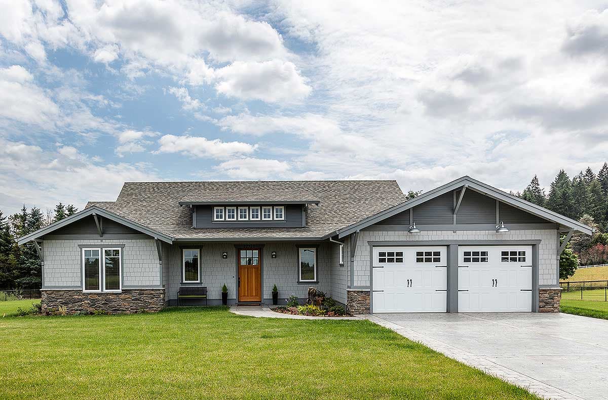 Craftsman style house plan exterior with a prominent dormer, stone base, and a three-car garage.