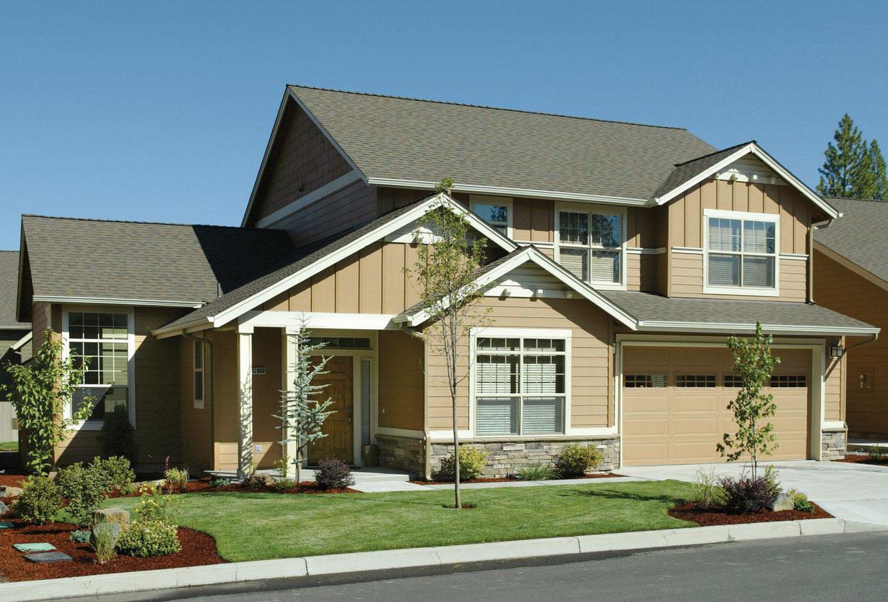 Two-story house plan exterior with prominent gables, vertical siding, stone accents, covered entry, and a two-car garage.