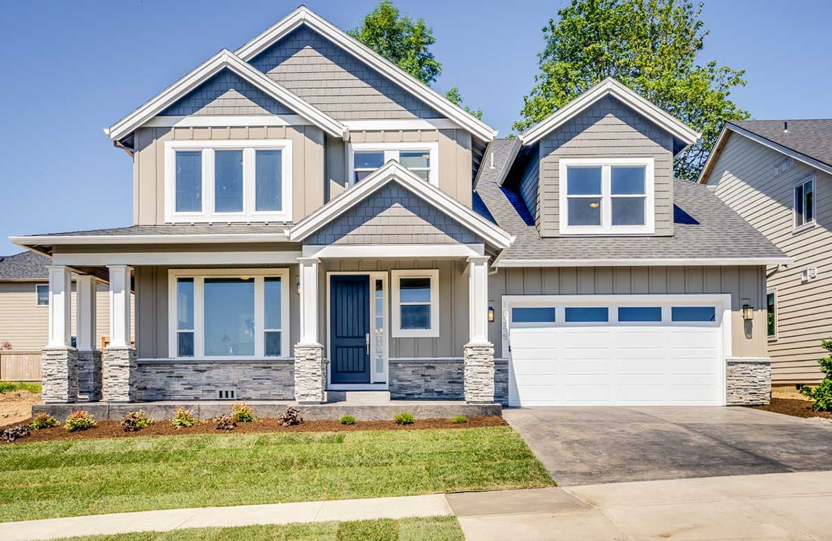 House plan exterior. Two-story Craftsman home with a front porch, multiple gables, and a garage with a four-panel door. Features a stone facade.
