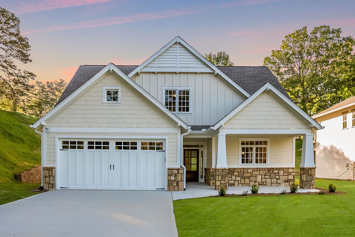 House plan exterior featuring a Craftsman style. The one-story home has a front-facing garage, gables, and a covered porch with stone columns.