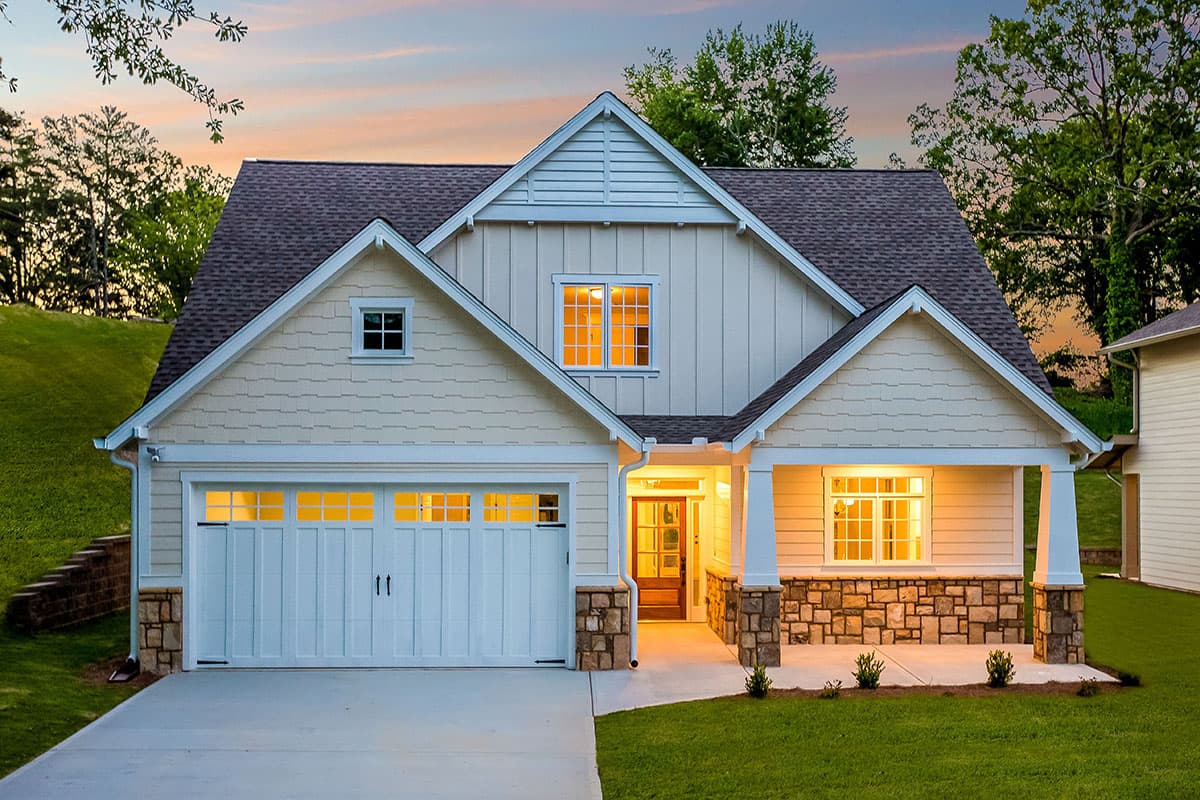 House plan exterior: Modern Farmhouse style, two stories, prominent gables, stone-accented porch with columns, and a side-facing garage.