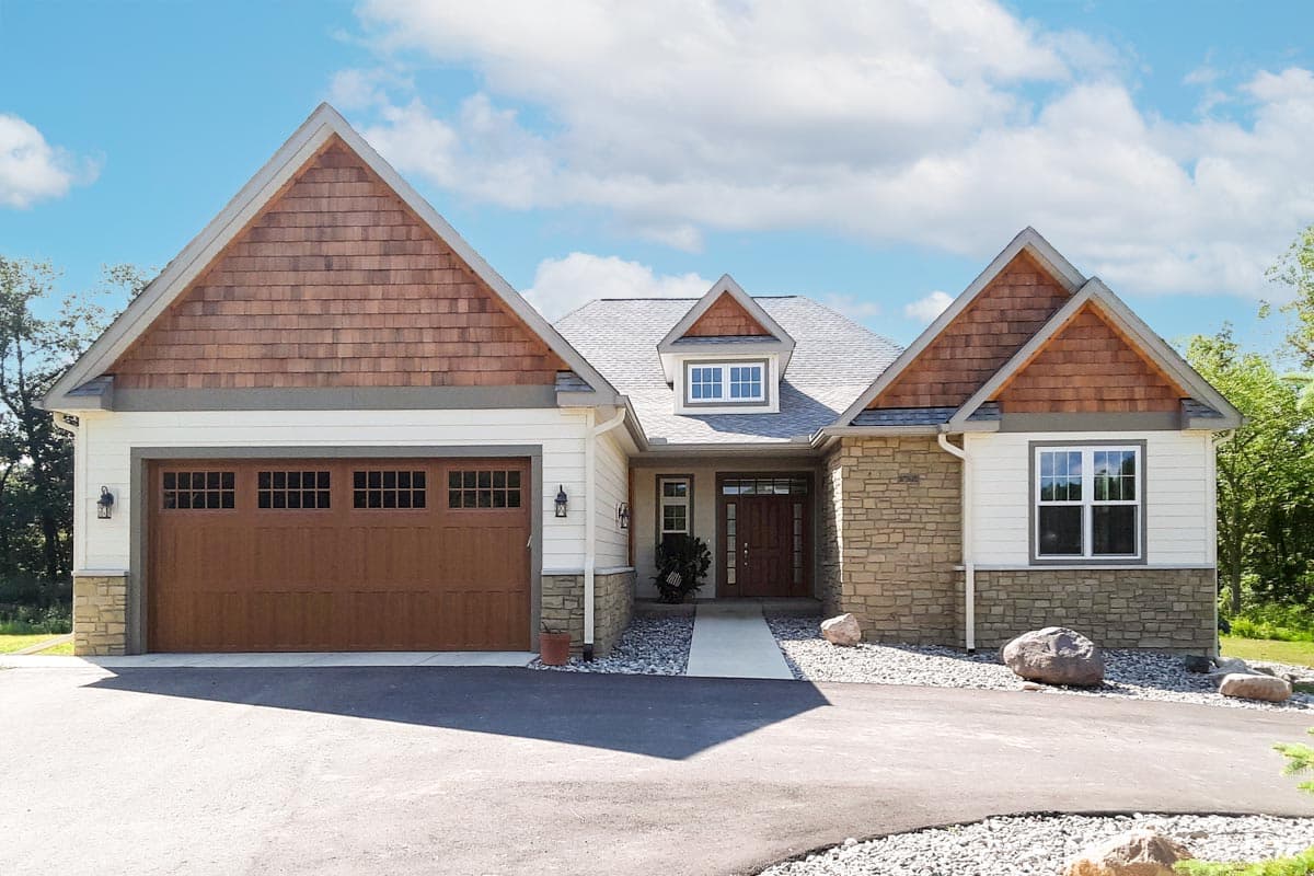 House plan exterior with Craftsman-style elements. Features include a gable roof, wood-clad gables above the garage, and stone veneer accents.