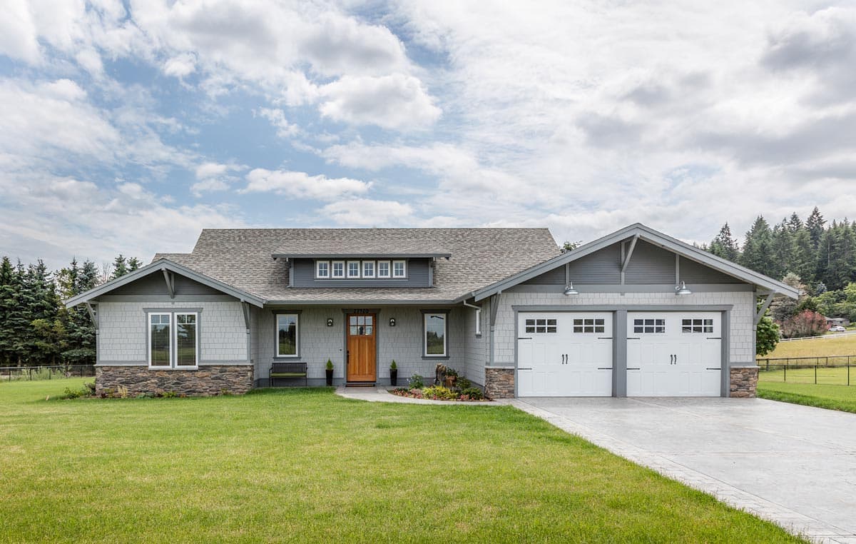 Craftsman style house plan exterior with a covered front porch, dormer windows, and a three-car garage.