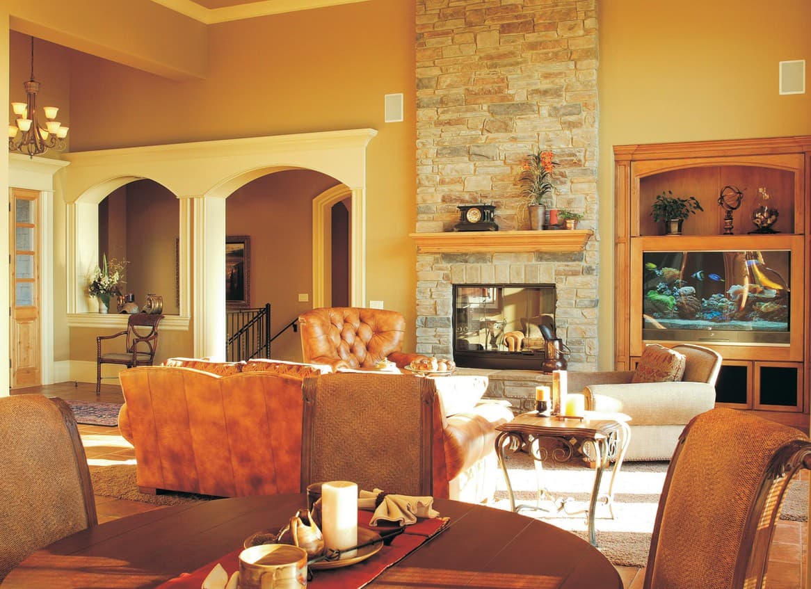 Living room with stone fireplace, built-in entertainment center, and arched doorways leading to other rooms.