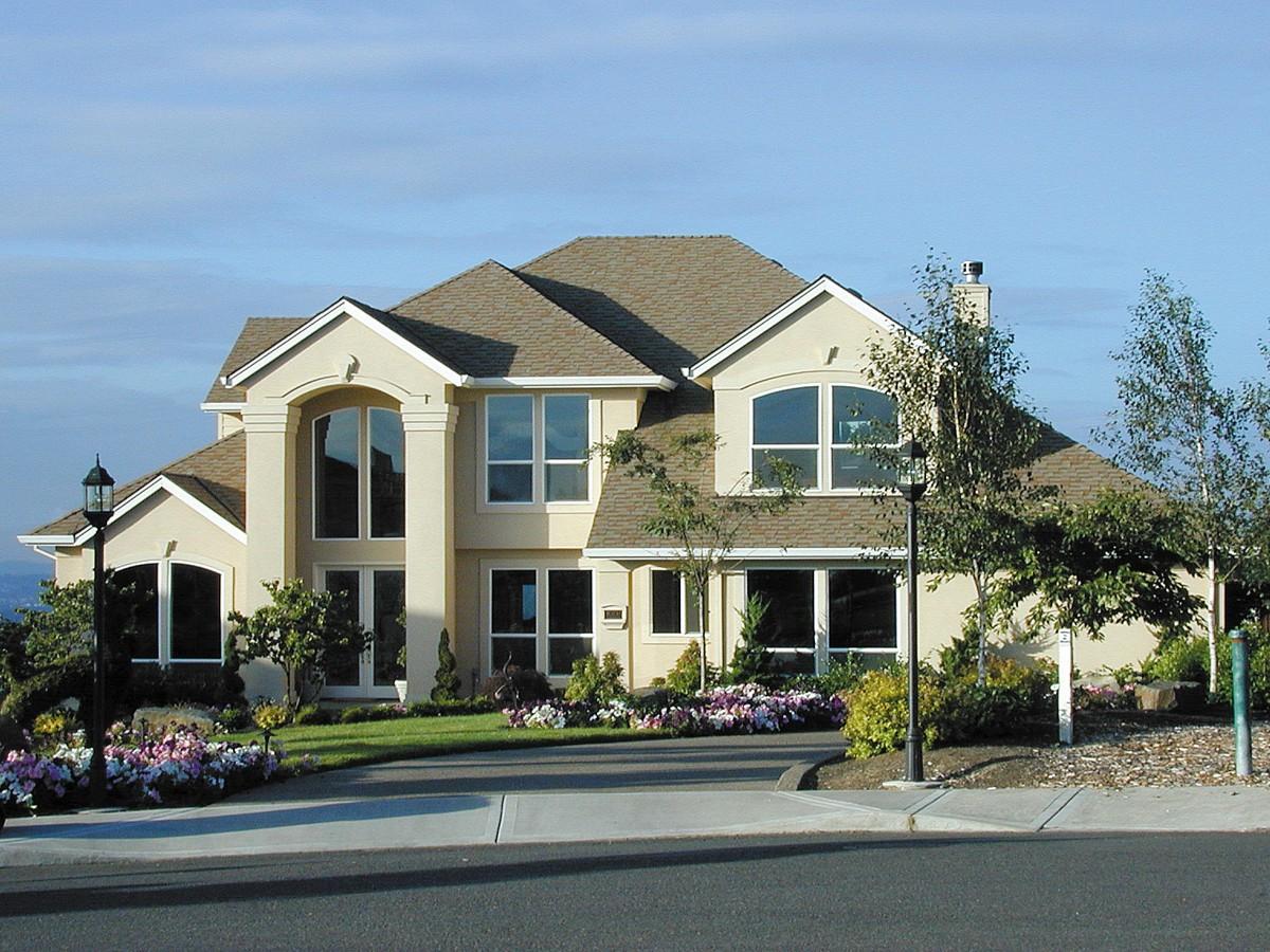 House plan exterior for a two-story home with stucco facade, arched window features, prominent gables, and multiple rooflines.
