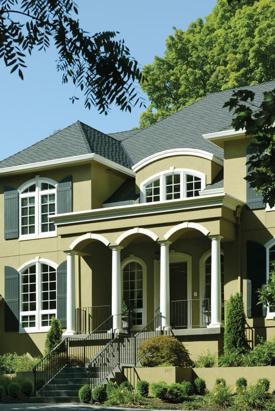 House plan exterior: Two-story house with arched windows, shutters, and a covered entry porch with columns.