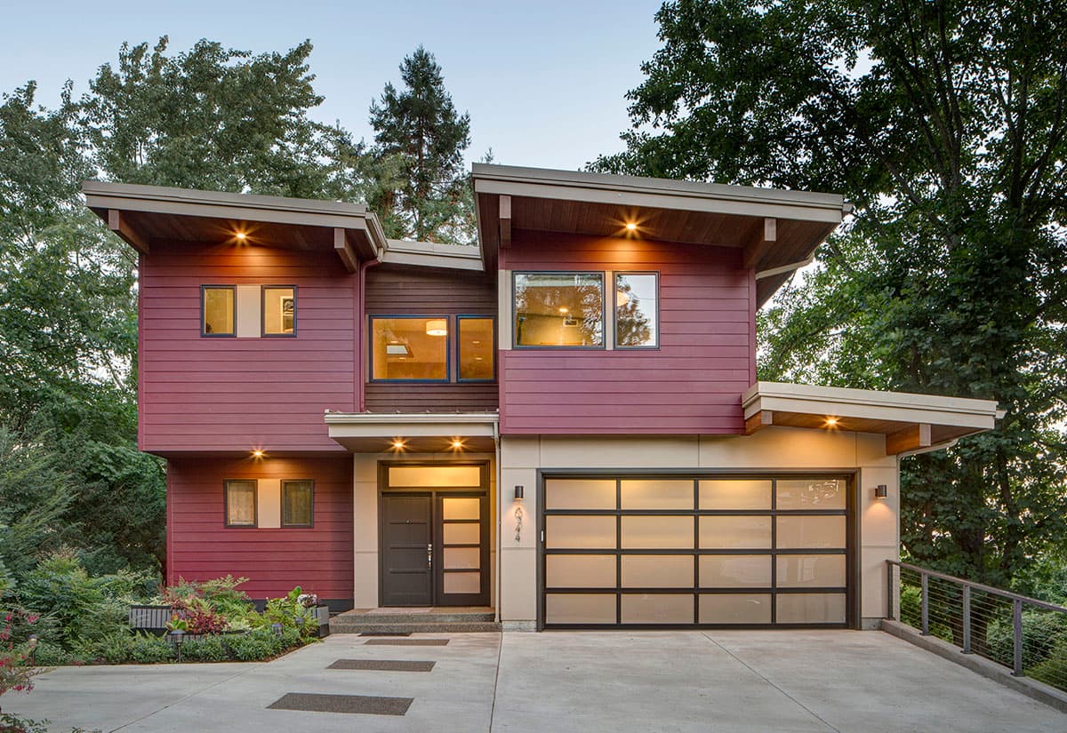 Modern house plan exterior with a two-story design, cantilevered rooflines, burgundy siding, and a glass-paneled garage door.