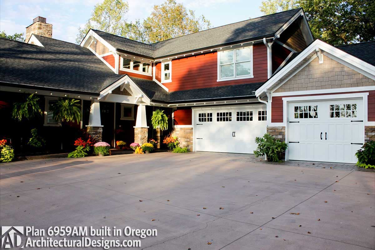 House plan exterior with dual garage doors, gabled dormers, stone accents, and a covered entry with stone-clad pillars.