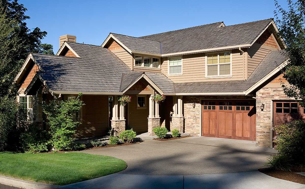 House plan exterior of a two-story home with a stone foundation, multiple gables, wood siding, and a three-car garage.