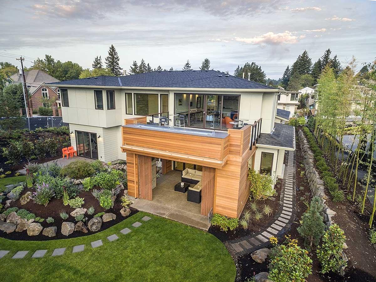Modern house plan exterior with multi-level design, wood siding, large windows, and covered patio.