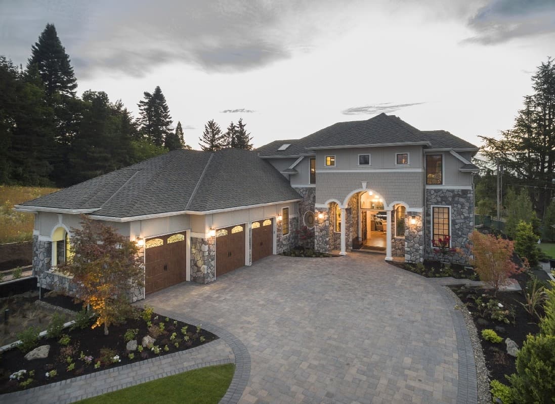 House plan exterior: Two-story home with arched entryway, stone accents, and attached three-car garage.