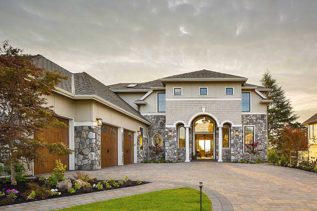 House plan exterior: Two-story home with stone accents, arched entry, and attached three-car garage.