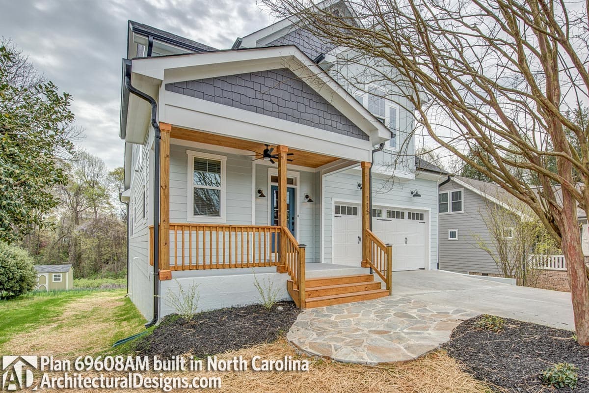 House plan exterior shows a two-story home with a covered front porch, wood railings, gables, and a double garage.