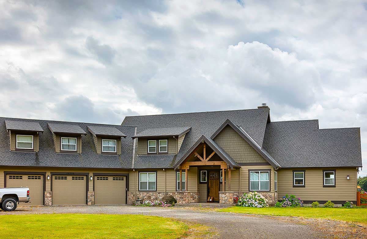 House plan exterior. Contemporary style, multiple gables, prominent entry overhang, and a three-car garage.
