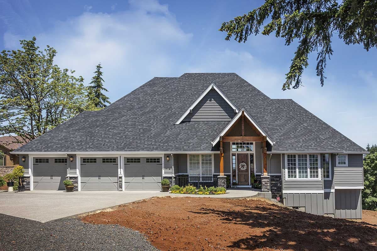House plan exterior. Two-story home with a gabled roof, a three-car garage, and a covered entry porch. Craftsman style.