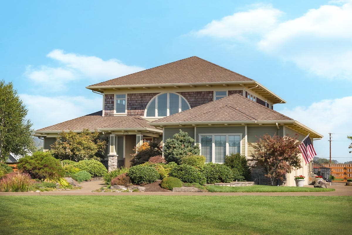 House plan exterior featuring Craftsman-style design. The two-story home includes a prominent roofline, arched window, and a covered porch.