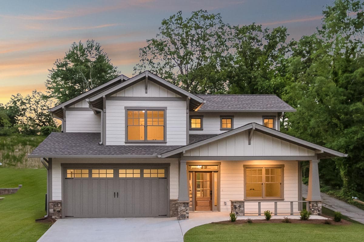 House plan exterior. Two-story Craftsman home with gabled roof, covered porch, and attached two-car garage. Features lap siding and stone accents.