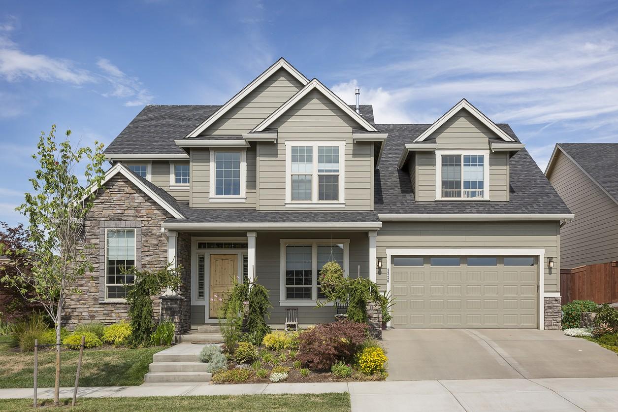 Two-story house plan exterior with stone accents, covered entry porch, multiple gables, and attached two-car garage.