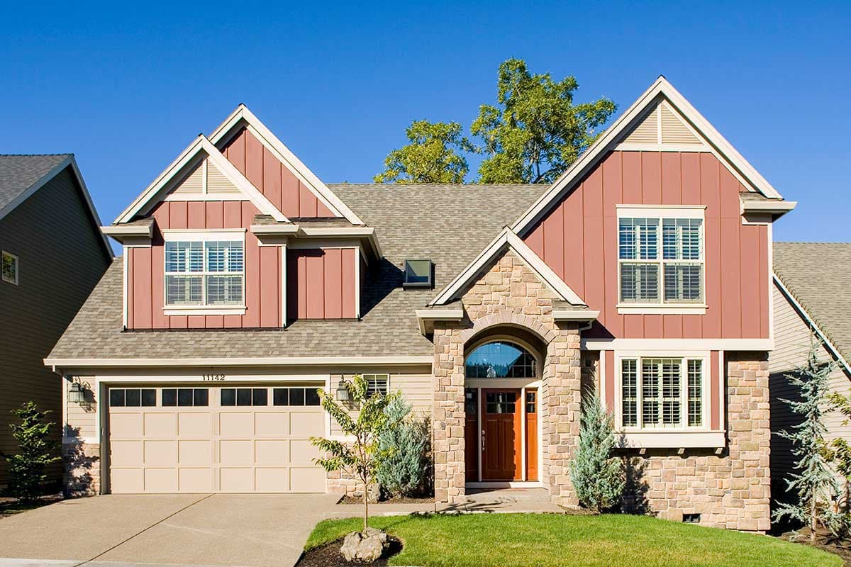 House plan exterior with Craftsman style, two stories, gabled roof, stone archway over entrance, and dormers.