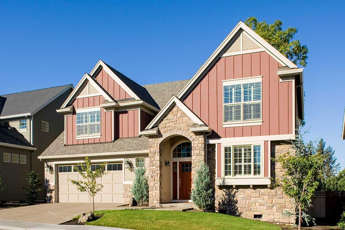House plan exterior: Two-story home with stone entryway, gable dormers, vertical siding, and a side-entry garage.