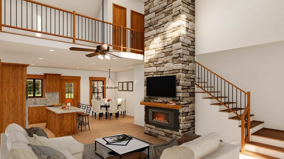 Open concept great room with stone fireplace, kitchen island, dining area, and lofted second floor.