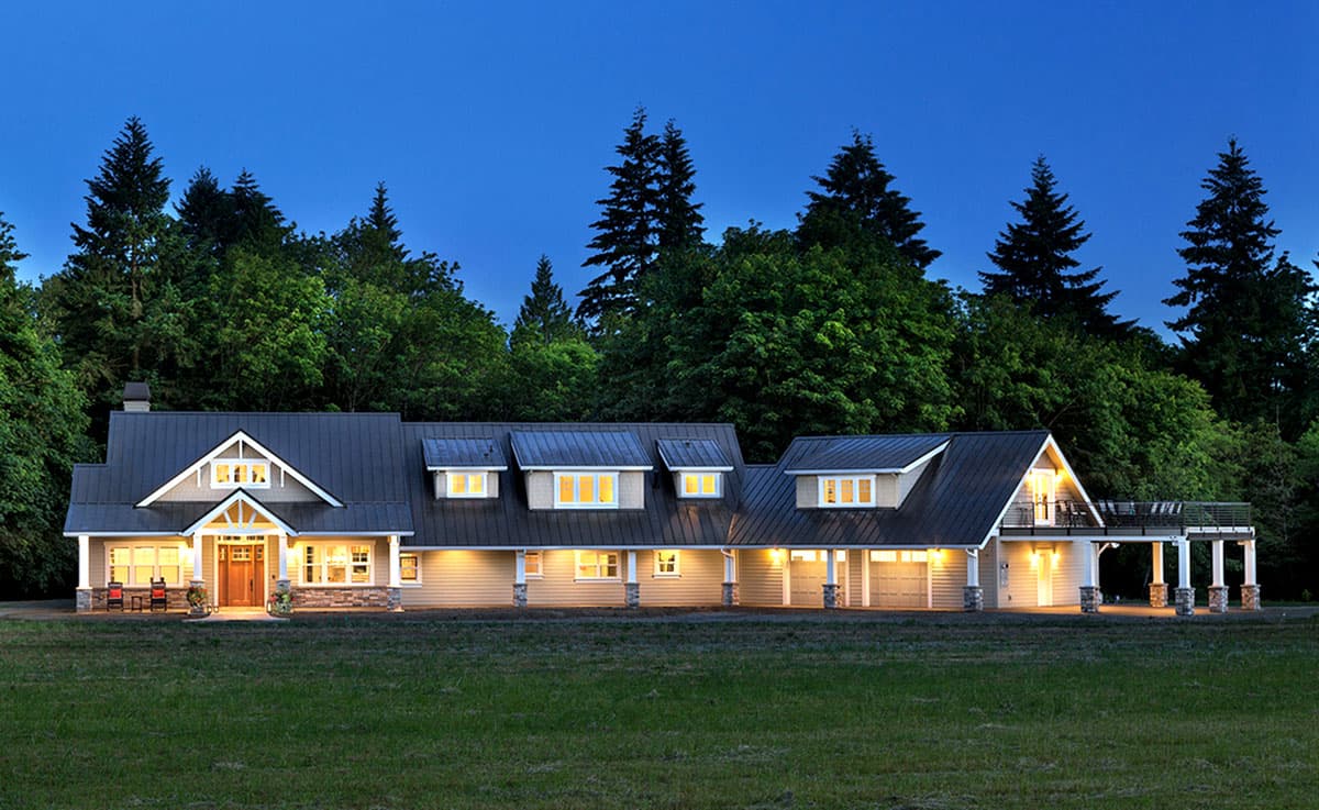 House plan exterior: Ranch style, main-level living, prominent gables, wide porch, and attached three-car garage.