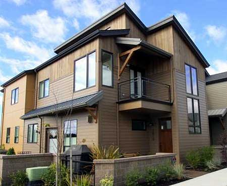 House plan exterior: Modern style, three stories, with wood siding, balcony, and gabled rooflines.