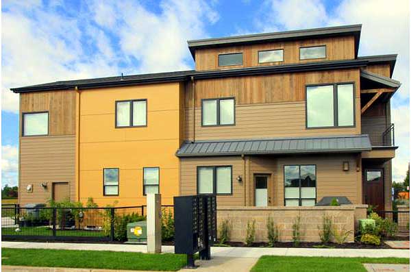 Modern house plan exterior with mixed siding, multiple windows, and flat rooflines across two stories.