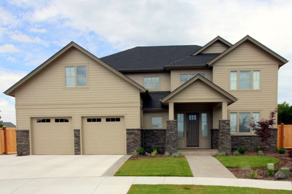 House plan exterior: Two-story contemporary home with a triple-window garage, stone-clad columns, and a covered front entry.