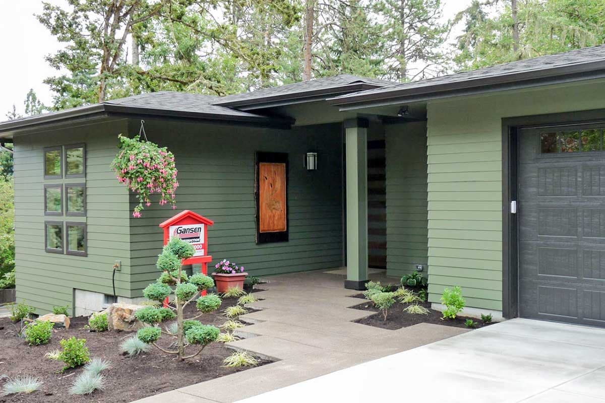 Modern house plan exterior with horizontal siding, large windows, attached garage, and covered entryway.