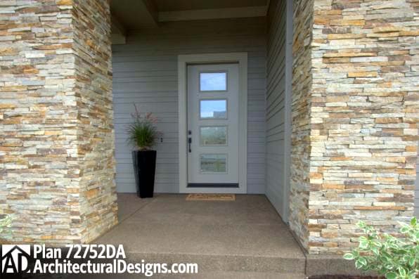 House plan exterior: Modern door with four glass panes flanked by stacked stone pillars and horizontal siding.