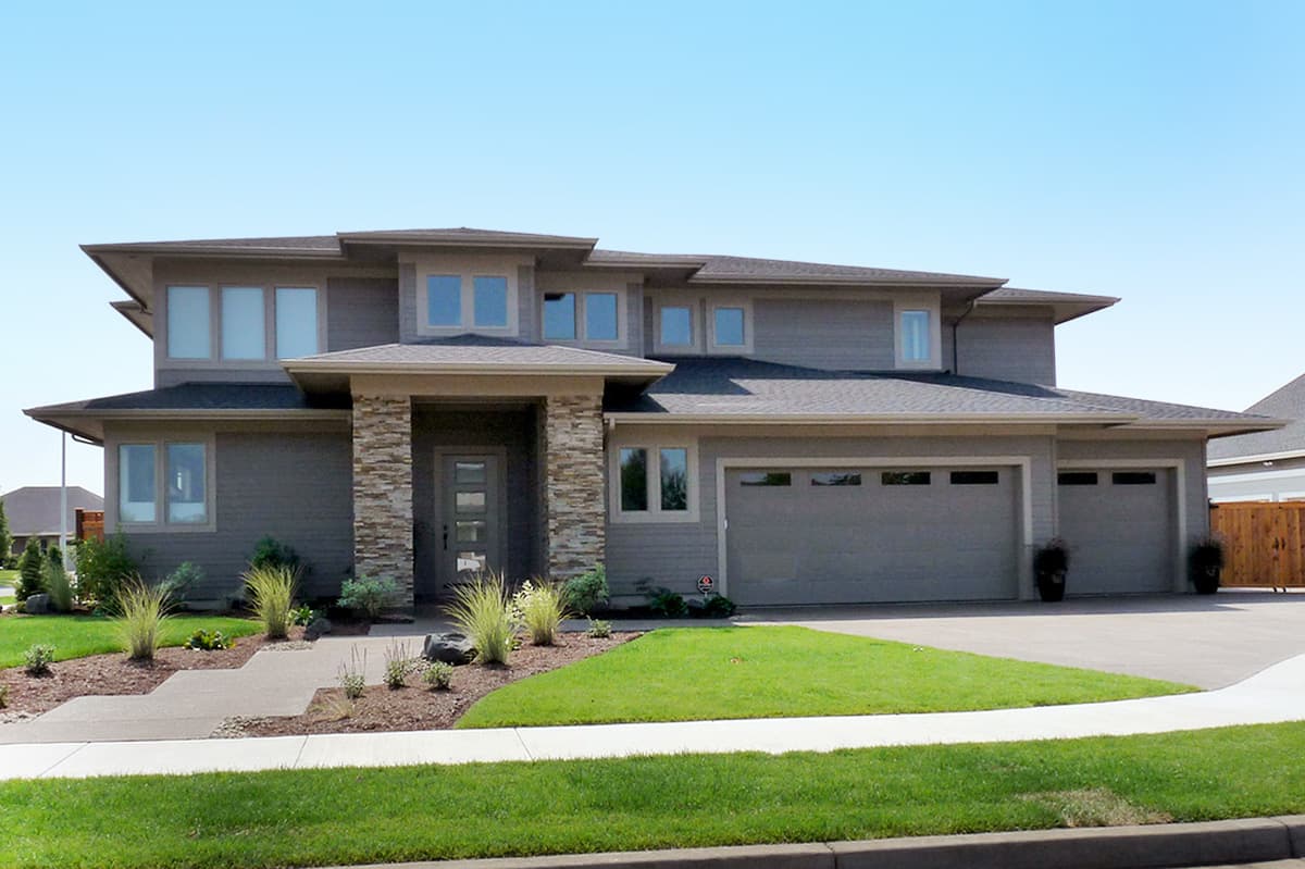 Modern style house plan exterior with stone accent entrance, multiple gables, and a three-car garage.