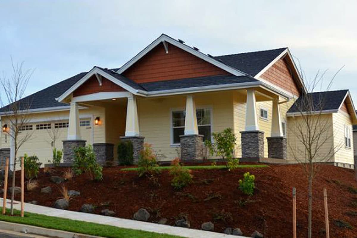House plan exterior: Ranch style, one story, covered entry with stone-clad pillars, gables, and wide eaves.