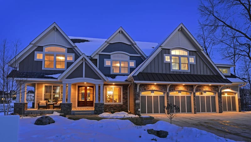 House plan exterior of a two-story home with multiple gables, a covered porch, stone accents, and a three-car garage.