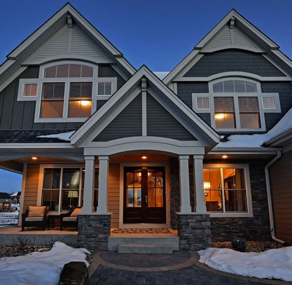 House plan exterior shows a two-story home with a covered front porch, stone accents, and multiple gables.