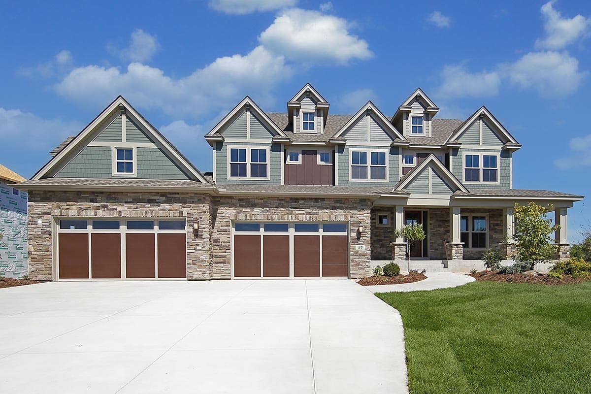House plan exterior. Two-story home with Craftsman style. Features include multiple gables, stone veneer on the garage, and a covered front porch.