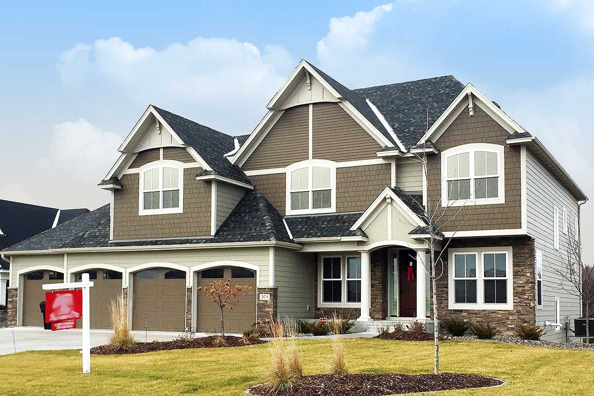 House plan exterior view of a two-story home. Features include a Craftsman style, multiple gables, arched windows, and a three-car garage.