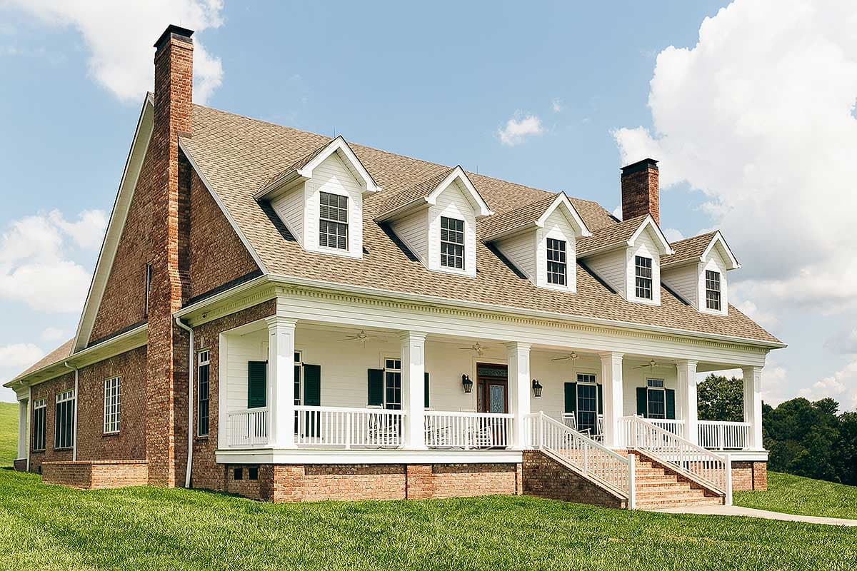 House plan exterior: Two-story brick and siding home with a wraparound porch, five gables, and two brick chimneys.