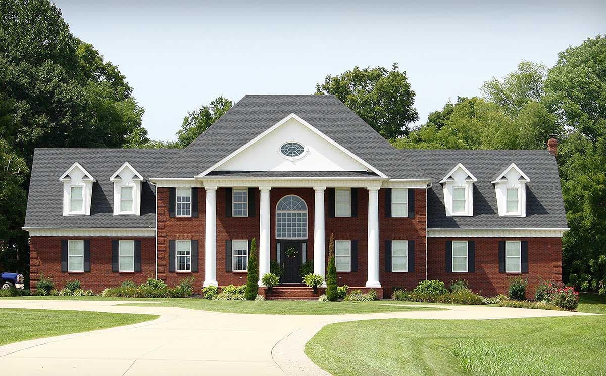 House plan exterior: Two-story brick home with a central portico supported by columns, hipped roof, and dormer windows.