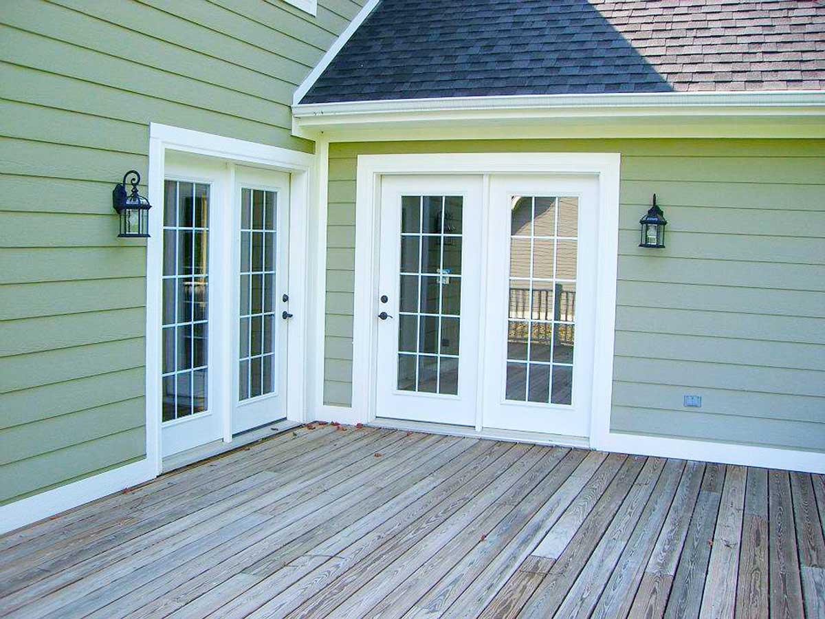 House plan exterior showing a wooden deck and two sets of white double doors with gridded glass panes.