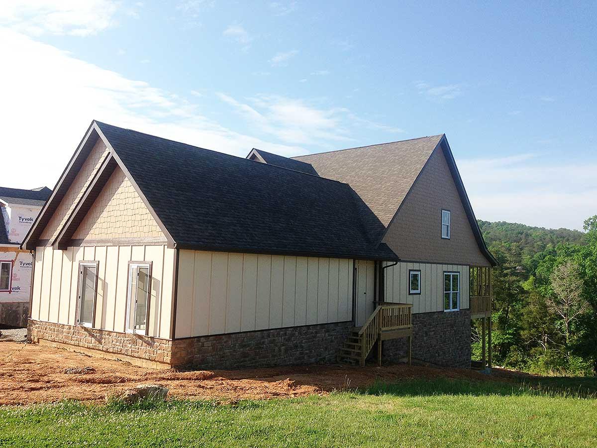 House plan exterior view of a two-story home with mixed siding, stone foundation, and prominent gables.