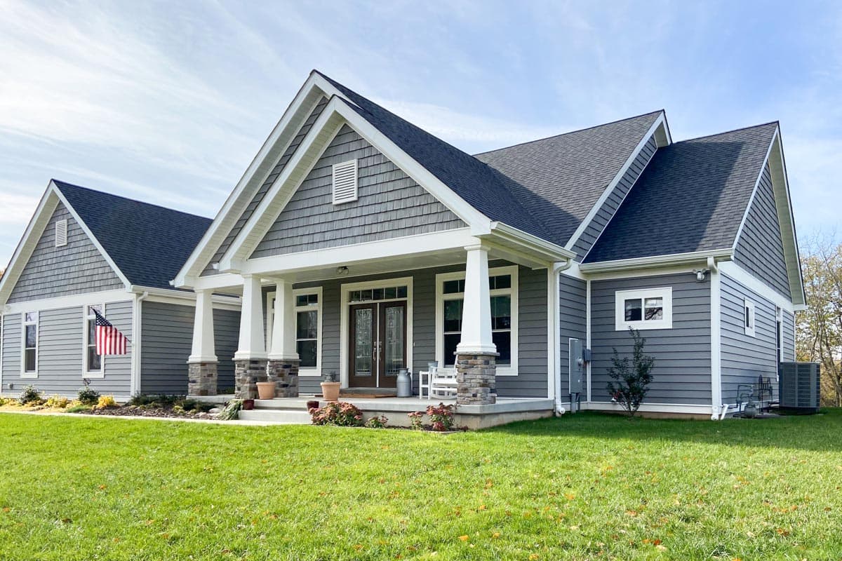 House plan exterior. Craftsman style, one-story house with a covered front porch, gables, and shake siding.
