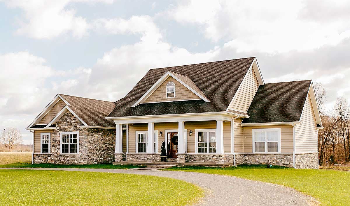 House plan exterior: Ranch style with stone accents, covered porch, gable dormer, and vinyl siding.